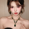 Elegant gold-tone jewelry set featuring teardrop-shaped green gems on a female model - 2# Gold Green Gemstone Necklace Earring Set (HN5047-2)