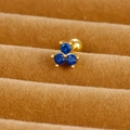 Macro shot of three royal blue zircons in a gold clover ear stud on brown velvet - Three-leaf Clover (E1233-3)