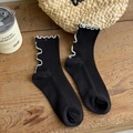 Retro black cotton mid-calf socks with white ruffle trim on a wooden background - One Size / Black