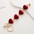 Macro shot of red velvet heart charms on a gold-plated DIY jewelry chain with magnetic clasp - Red