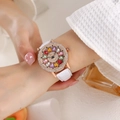 Primer plano de un reloj de mujer en oro rosa con pedrería y correa de cuero blanco - Cinturón / Blanco