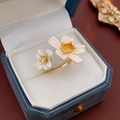 Detailopname van een vergulde bloemring met gele zirkoon in een luxe sieradendoosje - Dubbele Bloem Open Stijl (Goud Wit)