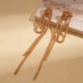 Detail van gouden kwastjes oorbellen met knoopontwerp en lange metalen kettingen - S925 Zilveren Pin / Goud