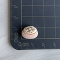 Macro view of a 1.5cm miniature resin bread model with pink base on a scale mat - 05*Dotted Beige Cream
