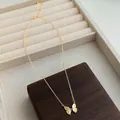 Détail du collier papillon plaqué or 18K avec zircon sur un écrin à bijoux en velours - Style Papillon Doré Zircon