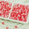 Close-up of 6mm pink and red cracked glass beads in a white ceramic sorting tray - Jade Texture Crimson (6mm)
