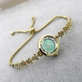 Detail of adjustable gold-tone flower link bracelet watch with shimmering green dial - Green