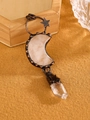Macro shot of bronze moon rose quartz and crystal pendant on natural wood background - White Crystal