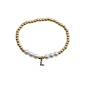 Detail of beaded bracelet with golden beads, white pearls, and a colorful zircon letter L pendant - Letter L