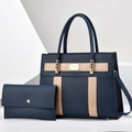 Detail of navy tote bag set featuring beige leather straps and gold metal hardware logo - Blue