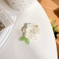 Elegante molletta per capelli a camelia bianca con foglie verdi e perla su sfondo bianco - Fermaglio Camelia con Foglie Verdi