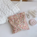 Floral cotton drawstring pouch with pink patterns shown next to beauty accessories - Red Orange Floral