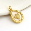 Close-up of 18k gold plated teardrop pendant with pearlescent center and crown detail - Gold Plated Copper/Enamel