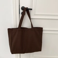 Close-up of a large dark brown canvas tote bag hanging from a door handle showing texture - Solid Coffee