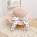 Detail of pink straw hat with wave brim and white polka dot bow on wooden stand - 52cm (2-5 Years) / Pink Straw Hat