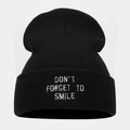 Detail of white 'DON'T FORGET TO SMILE' embroidery on black knitted beanie cuff - One Size / Black