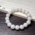 Detailed close-up of white bodhi root beads with smooth texture on dark wooden desk - White Jade Bodhi
