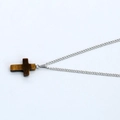 Detailed view of natural tiger eye stone cross pendant on a silver metal chain necklace - Brown