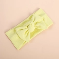 Close-up of yellow ribbed knit baby headband featuring a large bow on cream background - Neon Yellow