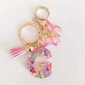 Pink resin letter G keychain with heart sequins, butterfly charm and silk tassel - Letter G