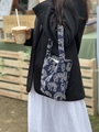 Detail of navy canvas handbag with white sheep print shown in an outdoor lifestyle setting - Navy Blue
