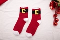 Gros plan de chaussettes de Noël duveteuses rouges et blanches avec motif Père Noël - Taille unique / Ceinture