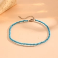 Detail view of a turquoise beaded anklet with titanium steel chain and lobster clasp - 2.5mm / Turquoise