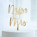 Close-up of golden Miss to Mrs cake topper with diamond ring design on white cake - Diamond Ring Shape MR&MRS