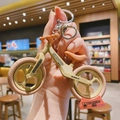 Beige and pink assembly bicycle keychain with metal ring on a warm cafe background - Khaki