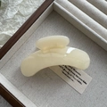 Macro shot of a cream-colored minimalist hair claw clip in a rustic wooden jewelry box - Fruit White
