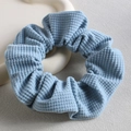 Dettaglio dell'elastico per capelli in velluto blu su vassoio bianco, stile francese - Blu scuro