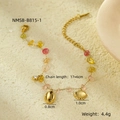 Detailed view of 18K gold starfish bracelet with colorful stones on sandy background - Bracelet / Gold/Multicolor