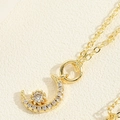 Détail macro d'un pendentif lune en plaqué or 14K orné de pierres de zircon brillantes - Collier Lune en Zircone