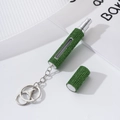 Detail showing the green rhinestone-encrusted perfume spray bottle with key ring - Green