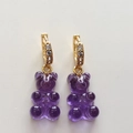 Macro view of purple gummy bear earring with gold clasp and zircon stones on white background - Transparent Purple