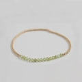 Detail of beaded bracelet with faceted olive green stones and polished gold metal beads - Peridot