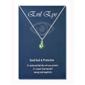 Detail view of green evil eye charm necklace on a blue good luck gift card - Steel Color Green Bead (Black Eye)