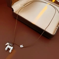 Vue détaillée d'un pendentif cheval argenté avec gland sur un cordon en cuir brun - 5# Collier-Argent-Marron