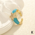 Detailansicht goldener Sternring mit türkisfarbener Emaille und Zirkonia-Besatz - Einstellbar Offen / Stern / Blaugrün