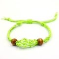 Detail eines verstellbaren neongrünen Webarmbands mit Holzperlen und Netz für Edelsteine - Grünes Armband