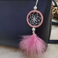 Pink dreamcatcher bag charm with soft feathers and beads on a blue handbag accessory - Pink