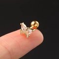 Close-up of golden butterfly ear stud with zircon stones held between fingertips - CC016-2 Gold Bow Knot
