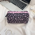 Gesteppte Kosmetiktasche mit Blumenmuster und rosa Reißverschluss auf Schreibtisch - Schwarz mit rosa Blumenmuster