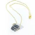 Detailed shot of irregular natural raw crystal pendant with fine golden chain necklace - Black Spectrolite