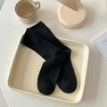 Vertical ribbed black wool mid-calf socks in a minimalist cozy home setting - One Size / Black
