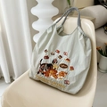 Detail of cat embroidery and striped handles on light green nylon tote bag on a chair - Light Grey Chocolate Cat