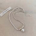 Détail d'un ensemble de bijoux vintage en perles et argent avec un pendentif coeur - Collier