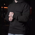 Detail of black hoodie featuring a functional chest flap pocket and soft cotton texture - S / Black