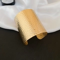 Macro shot of wide gold cuff bracelet featuring irregular hammered honeycomb texture - Honeycomb Hammered Style (1#) / Gold