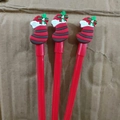 Three red Christmas themed gel pens with decorative red and grey striped holiday socks - Glove Red